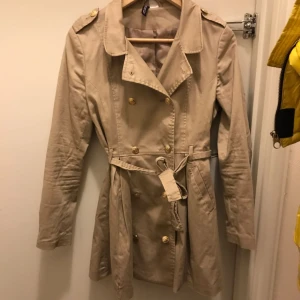  - Trenchcoat från hm, jag har bytt ut knapparna. Fint skick, modell som går ut lite vid midjan. 