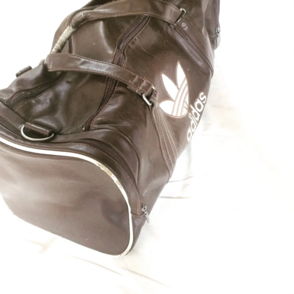 Adidas trunk i brunt och vitt! Perfekt som minsta resväska eller gymväska.. Väskor.