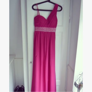  - Elegant balklänning i flirtig färg! Jätteskön att ha på sig och enkel att röra sig i. Finns ett hål på framsidan som går att laga där av det låga priset!