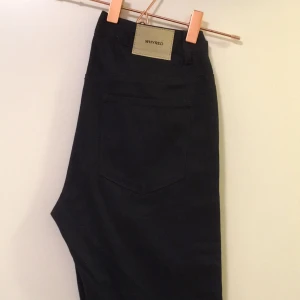 - Mörk-mörkblåa Whyred jeans, rak modell.