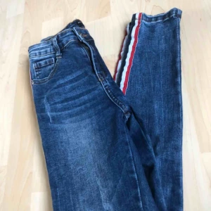  - Skit snygga jeans med en röd, vit och blå revär längs med sidan. Använt fåtal gånger så är fortfarande i nyskick.