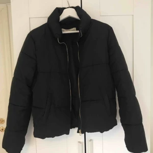  - Trendig och enkel dunjacka med hög krage och guldig dragkedja, sparsamt använd. Hör av er om ni har några frågor<3