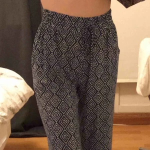  - Marinblåa mönstrade byxor, fladdriga och i skönt material med superhög midja. Strl S funkar även som XS. Är fulllånga på mig som är 165 lång men går även att ha längre ner i midjan