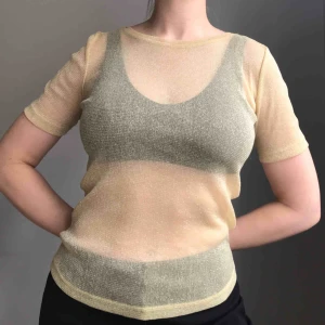  - Glittrig, transparent topp i stretchigt material från Zara i storlek M • färgen är varmare och mer guldig än på bilderna • perfekt både under och över andra plagg • använd ett fåtal gånger så mkt bra skick! • frakt på 18kr tillkommer