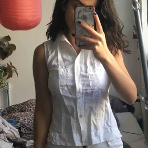  - Vit ärmlös blus med söt krage i linne. Toppen har två bröstfickor och är figursydd. Fint tyg.  