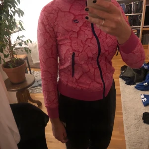 Jacka Nike i chockrosa  - Snygg chockrosa jacka som knappt är använd. Inköpt för tusen år sedan men nästan orörd då jag själv endast använder svart...
