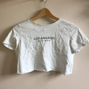 Vit croppad tröja - Vit croppad tröja med text ( Los Angeles ). Kommer tyvärr inte till min användning längre. Säljer billigare än vad den gjorde när jag köpte den.