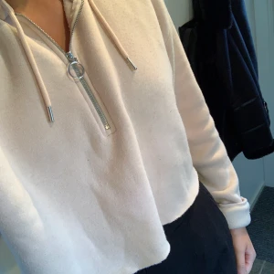 Croppad hoddie - Croppad hoodie i ljusrosa färg. Den var avklippt från början så inget jag har gjort själv :). Ganska lång i ärmarna. Knappt använd. 