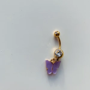 Navelpiercing fjäril - Världens finaste nacelpiercing med en ljuslila fjäril. Verkligen sjukt fin. Är guld med lila fjäril och diamant på båda kulorna. Köpt på neckontheline.com. Råkade köpa dubletter