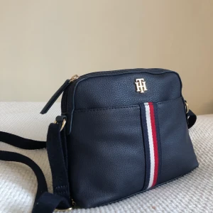 Liten tommy hilfiger väska 200kr  - Tommy hilfiger axelbandsväska inköpt i USA förra året i läder inte använd mycket. Bud från 200kr (inköpt för 600kr) i perfekt skick, fraktas eller möts upp i Uppsala.