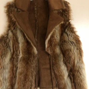 Pälsväst - Brun pälsväst från Ellos i storlek L, går att använda åt båda hållen. Kan mötas upp i Nyköpingsområdet men kan även frakta om köparen står för kostnaden av frakten.