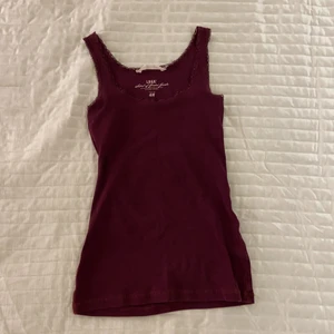 Lila/vinrött linne - Lila linne (skiftar vinrött) i strl S från H&M. Knappt använd. Spetsdetaljer.