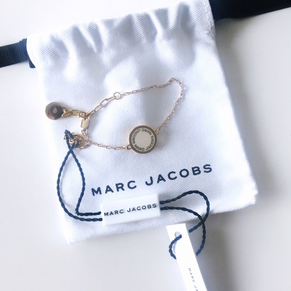Marc Jacobs armband i guld med vit platta. Helt nytt, tags och dustbag medföljer. Inget kvitto då jag fick det i present. Skickar eller möter upp i Stockholm. Accessoarer.