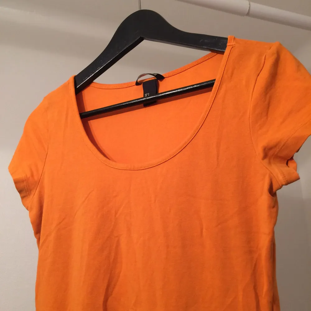 Härlig orange färg. Fodralklänning som när till halva låren ungefär.  Upphämt eller frakt . Klänningar.
