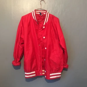  - Röd Vind jacka! Storlek M. Två knappar har åkt in i tyget men går att knäppa, inget som syns. Frakt 40kr..