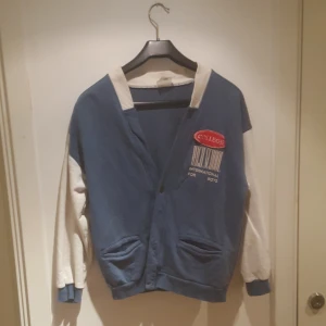  - Collegetröja i ganska liten storlek.  Den röda patchen sitter lite löst på en sida, men det går nog o limma/sy fast lätt.