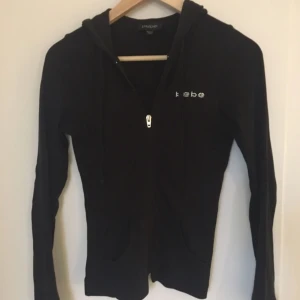  - Snygg och enkel svart hoodie med dragkedja från bebe. Använd men fortfarande i fint skick. 