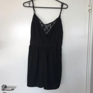 - Svart playsuit med spets i ryggen. 