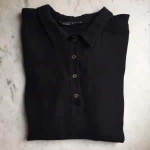  - Svart blus med elegant knäppning från Zara! Lite kort och liten i storleken så sitter nog bättre på en mindre storlek än L, skulle anta att den är som en 36/38 i storleken. Möts gärna upp i Göteborg, annars tillkommer frakt. Har swish! 