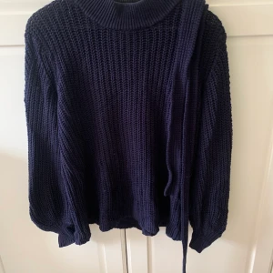 Stickad tröja  - Super snygg tröja från INDISKA väl använd. Finns band att knyta i midjan om man vill. Stor i storlek. Balongarmar. 