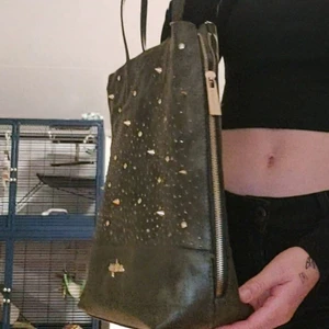 Militär grön väska med nitar  - En stor handväska med mycket detaljer såsom nitar, diamanter osv. Den är aldrig använd där med det exemplariska skicket. Insidan har många fack och har leopard mönster inuti.