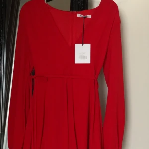 Oanvänd klänning från Nelly strl. 34 - Röd klänning med urringning. Aldrig använd. Längden går till halva låren på mig 170cm lång. 