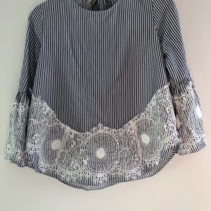 Blå/vit randig blus strl 36 - Blå/ vit randig blus med öppen rygg, och mönster nertill