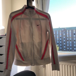 Nike kofta - Snygg nike kofta med lite sportigare stil. 2 dragkedjefickor på båda sidor. Koftan är i bra skicka knappt använd, lite genomskinlig som ni ser på bilden