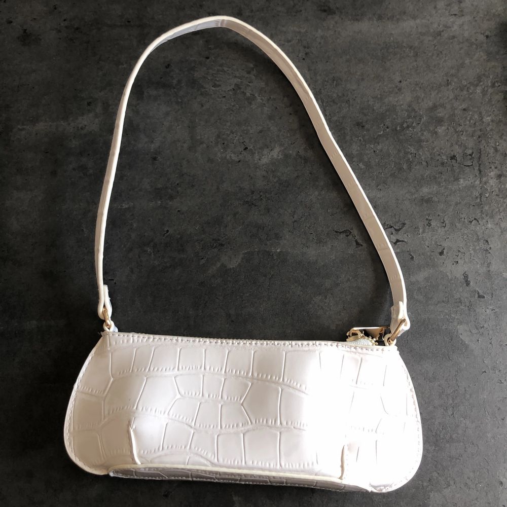 En så fin shoulder bag från ASOS! Den är vit med krokodilmönster med guldiga detaljer. Köpt här på plick då den var i nyskick och jag har aldrig använt den så den är fortfarande helt oanvänd!! Skriv gärna till mig vid frågor💜✨. Väskor.