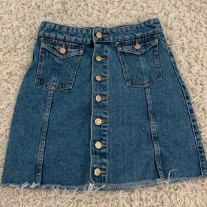 Jeans kjol - En snygg jeans kjol som sitter åt. Den är ganska kort. Ordinarie priset 399kr. Köparen stå för frakten.