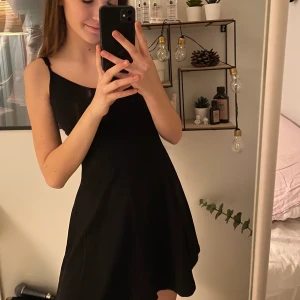 Klänning - Basic, svart klänning till knähöjd ungefär, justerbara axelband