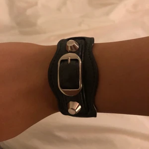 Balenciaga armband - Köpt på Nathalie schuterman för ca 2 år sen. Armbandet är i äkta skin. Nypris ca 2 500 kr. Har använts ganska mycket därför är texten på insidan lite försvunnen. Armbandet är grått. Säljer endast vid bra bud! Dustbag medföljer!!