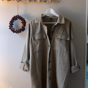 Cardigan/kappa - En beige kappa/cardigan från verk Moda. Aldrig använd. Går att ha långa armar eller vika upp. 
