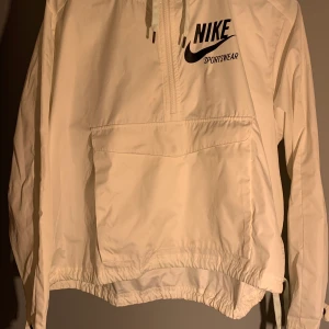 Vit träningströja/jacka från Nike stl M.  - Tunn vit träningströja/jacka från Nike stl M. Jag har använt den som en tunnare jacka ute vid träning, vattentålig. Går att spänna åt i magen. Använd men väldigt bra skick. Säljer för 350kr. 