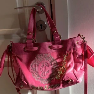 Juicy Couture väska  - Supersnygg väska i toppskick från Juicy Couture. Kommer tyvärr inte till användning längre. Små slitningar på handtagen, men syns knappt ens på bild. Medföljer långt axelband och nyckelring. Frakt tillkommer💕