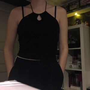 Svart ribbat linne med snörning runt hals - H&M Divided linne i halterneck design med justerbar snörning att knyta runt halsen, på gränsen till cropped, jag är 174cm och bär strl S men då tyget är stretchigt passar det dig som har storlek S-M!