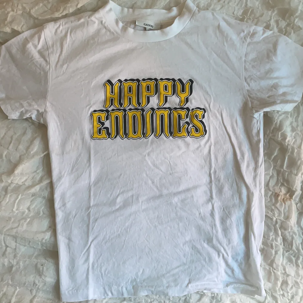 Vit t-shirt med trycket ”happy endings” i storlek M (skulle säga att det är en liten M) från Ganni. Använd kanske 5 gånger max, så skicket är väldigt fint. Köparen står för frakten som tillkommer 💖. T-shirts.