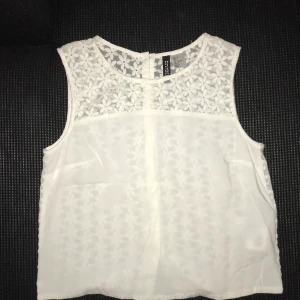 Kroppad topp  - Vit söt liten topp! Gulligt blommönster på baksidan! Storlek 34 och säljer pga att den är för liten för mig🤍