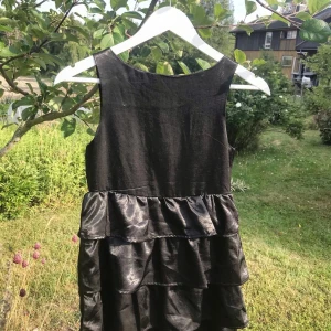 Klänning - Klänning i begagnat med mycket bra skick. Snyggt glansigt tyg med en silvrig dragkedja i ryggen.