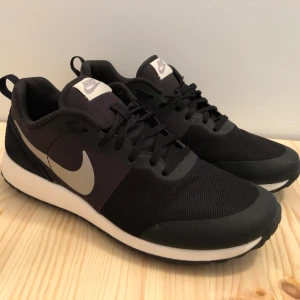 Svarta Nike sneakers - Klassiska lätta sneakers från Nike, storlek 38,5 men passar en 38a. Använda ganska sparsamt, skickar gärna fler bilder.  Finns i Kortedala, kan även skickas mot porto. 