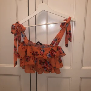 Topp från pretto little Things - Orange blommig, axelbanden knyter man själv och kan alltså ändras efter önskvärd längd. Str 32 