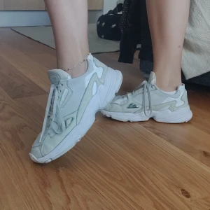 Adidas Falcon White/silver - Säljer mina jättefina adidas Falcon, pga platsbrist i garderoben! Väl använda, lite slitage vid hälen, annars inget fel på dem! Jättebekväma, storlek 38 2/3. Men lite mindre i storlek! Skickar gärna, frakt tillkommer🤗🤗 Buda gärna!!