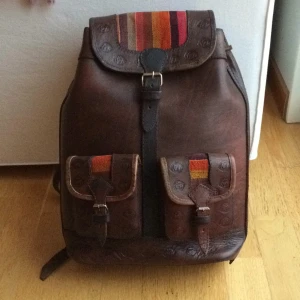  - Lagom stor ryggsäck i skinn med färgade tygdetaljer. "Kånken"-storlek.
