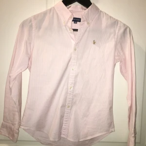  - Säljer en Ralph Lauren skjorta i barnstorlek 150, men passar även en XS, dvs 32/34. Frakt ingår. Tar swish! Ljusrosa och vit.