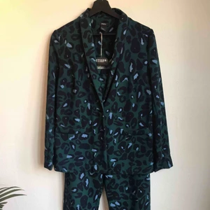  - Kostymset i leopardmönster.  Byxa st XS (resår i midjan)  Kavaj st S  Polyester.