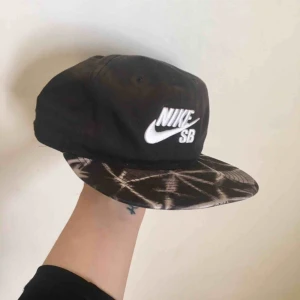  - Keps från Nike med spänne i bak. I sjukt snyggt batik/stentvättade är mönster på skärmen och svart i övrigt. Sparsamt använd.