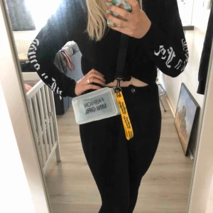  - Söt liten handväska i genomskinlig ”plast”. Tryck ”Mini fashion girl”, text på bandet ”ordinary unique!”. Aldrig använd.