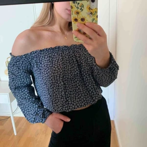  - Mörkblå off the shouldertopp med vita blommor ursprungligen från Brandy Melville. ONE SIZE men skulle uppskatta XS-M, då den är stretchig i axlar och midja, croppad. Endast använd någon enstaka gång, superbra skick. 
