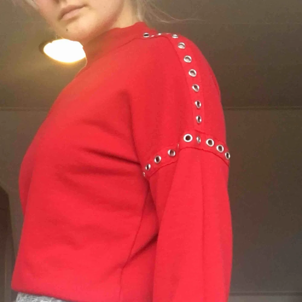 Jättefin klarröd sweatshirt med silvriga hål/nitar, bra parrform. Säljer pågrund av att den inte används. Kan mötas upp i Stockholm eller skickas på posten (köparen står för frakten) 💕. Hoodies.