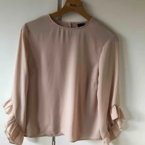  - Fin blus med volang från ginatricot. Beige/ljusrosa färg. Använd ett fåtal gånger. Frakt tillkommer ✨